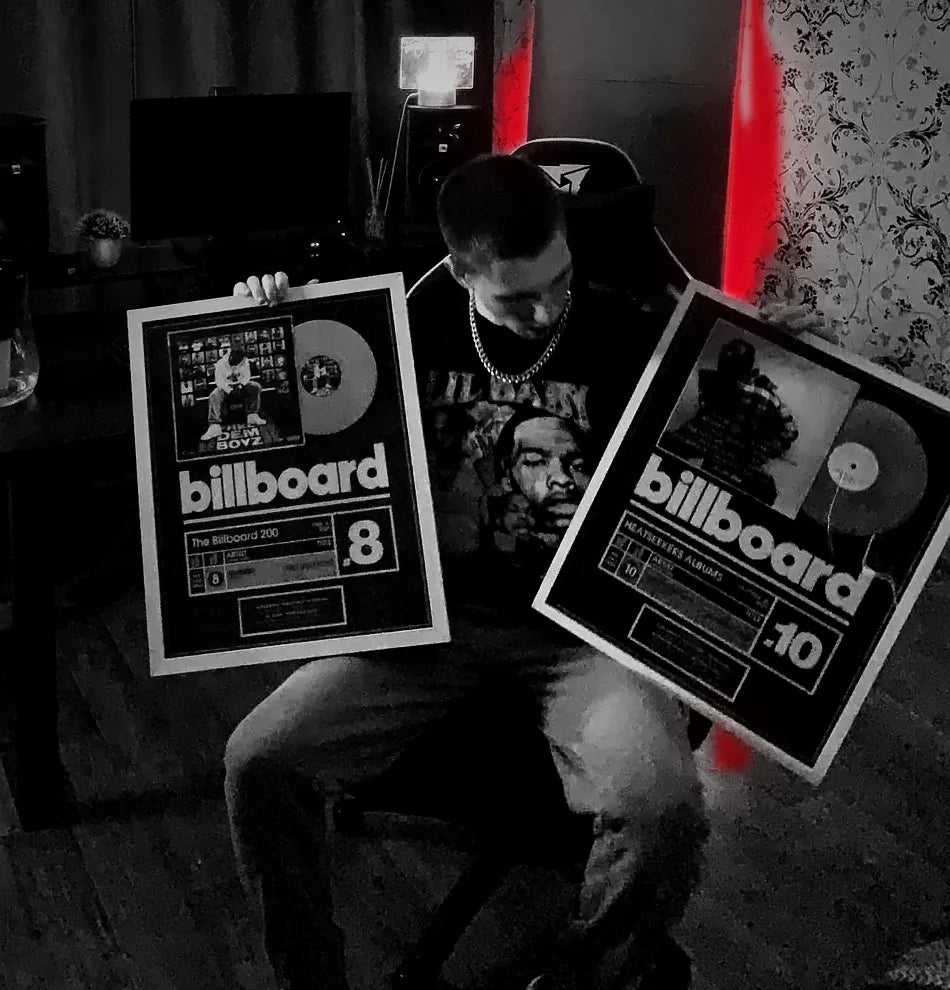 WristyBoi in the studio holding his Billboard 200 and Heatseekers Albums plaques